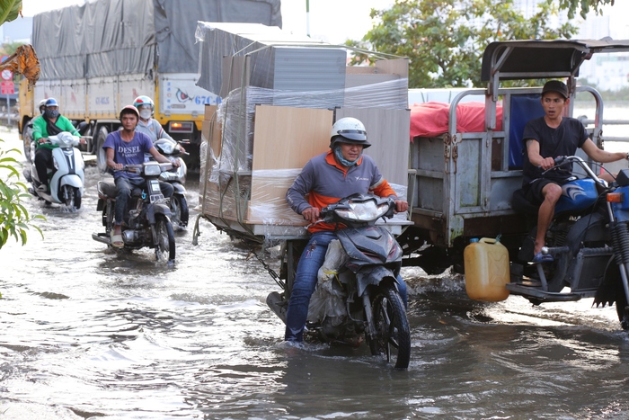 Người dân TPHCM chật vật mưu sinh trong ngày triều cường - Ảnh 2.