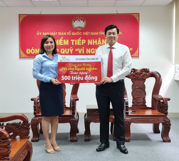 Đ/c Vũ Đình Ty, Phó Giám đốc Agribank Long An  trao bảng tượng trưng ủng hộ Tết vì người nghèo tại UB Mặt trận Tổ Quốc tỉnh Long An