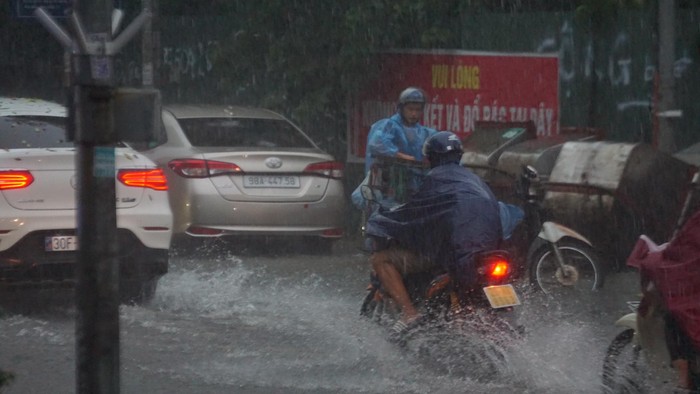 Mưa lớn bất ngờ ở Hà Nội khiến nhiều người trở tay không kịp, xe cộ &quot;vật lộn&quot; trong nước - Ảnh 7.