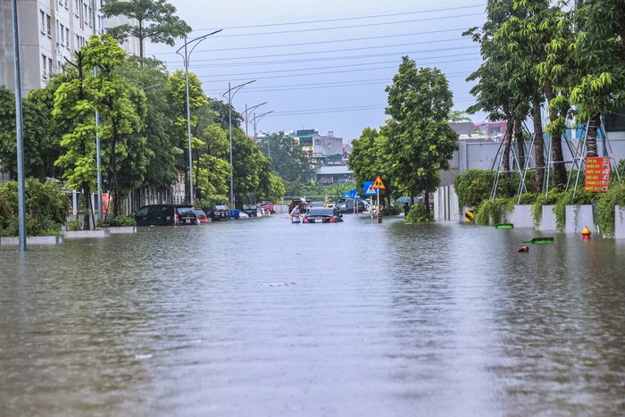 Đường phố Hà Nội biến thành “sông”, người dân bì bõm lội nước - Ảnh 12.
