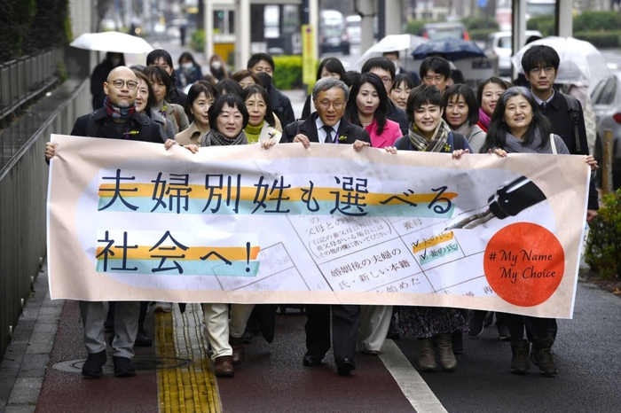 Các cặp đôi giơ khẩu hiệu yêu cầu được giữ họ của mình trước tòa án Tokyo ngày 8/3 vừa qua