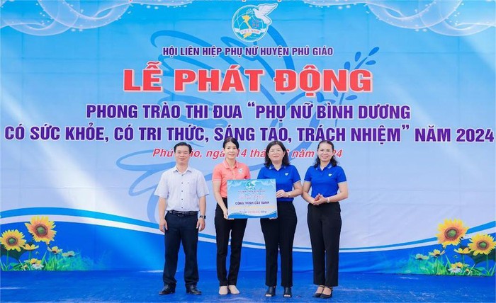 Chị Nguyễn Thị Bích Vân, Chủ tịch Hội LHPN huyện Phú Giáo (thứ hai từ phải sang) trao bảng tượng trưng công trình cây xanh tại lễ phát động phong trào thi đua “Phụ nữ Bình Dương có sức khỏe, có tri thức, sáng tạo, trách nhiệm”