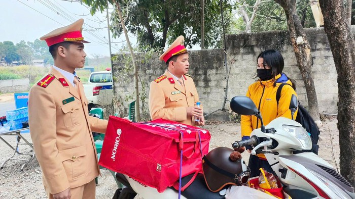 Tuyên Quang: Cảnh sát giao thông tặng nước uống, áo ấm, thay dầu xe đón người dân về quê ăn Tết- Ảnh 1.