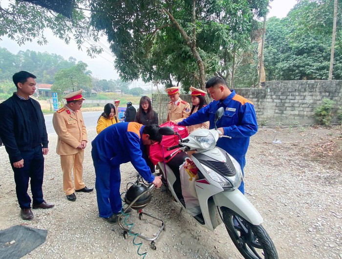 Tuyên Quang: Cảnh sát giao thông tặng nước uống, áo ấm, thay dầu xe đón người dân về quê ăn Tết- Ảnh 2.