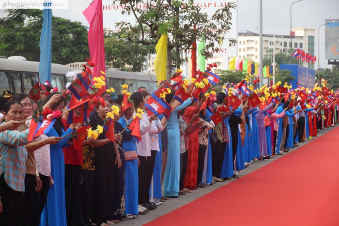 Nhân dân vẫy cờ chào đón đoàn đại biểu. Ảnh: Hồ Lam