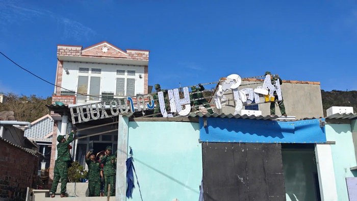 Dọn biển quảng cáo bị gió bão thổi rơi xuống mái nhà dân. Ảnh: Hữu Thoại Dọn biển quảng cáo bị gió bão thổi rơi xuống mái nhà dân. Ảnh: Hữu Thoại