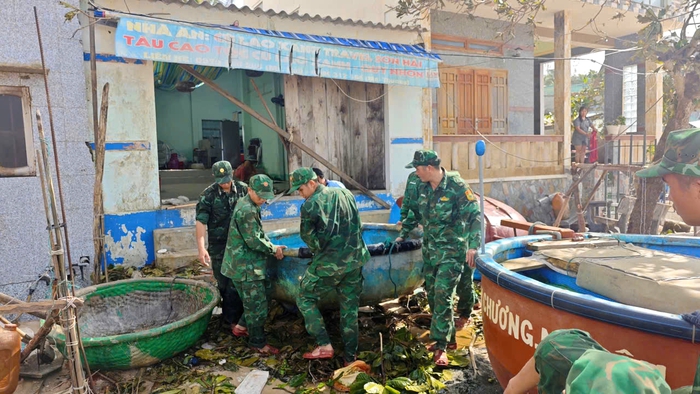 Di chuyển thuyền thúng nhỏ bị sóng biển xô dạt trước cửa nhà dân. Ảnh: Hữu Thoại Di chuyển thuyền thúng nhỏ bị sóng biển xô dạt trước cửa nhà dân. Ảnh: Hữu Thoại