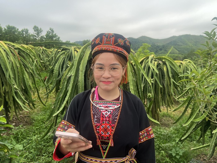 Phụ nữ xã Yên Phú, Tuyên Quang bán thanh longtrên nền tàng sổ với chiếc điện thoại cầm tay