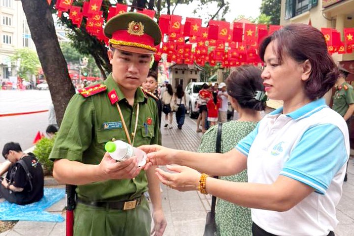 Hà Nội: Cán bộ Hội phục vụ nước uống, phát áo mưa cho nhân dân xem tổng luyện diễu binh, diễu hành 2/9- Ảnh 1.