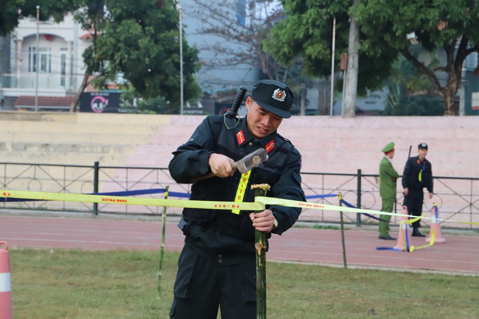 Một chiến sĩ CSCĐ Công an tỉnh Điện Biên đang gia cố lại hàng rào bảo vệ phiên tòa.