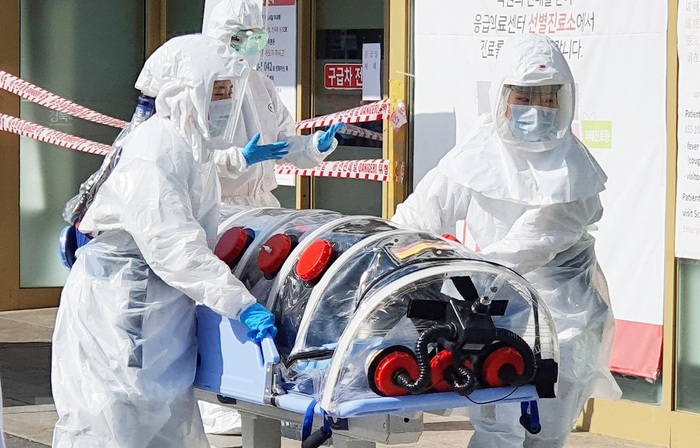 Nhân viên y tế chuyển bệnh nhân nghi nhiễm Covid-19 tới một bệnh viện ở Daegu