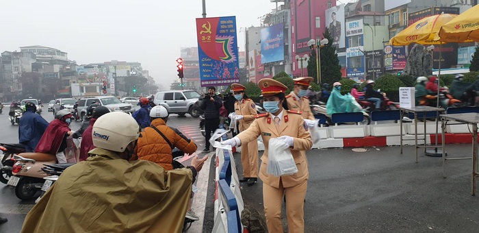 Các nữ cán bộ, chiến sĩ Phỏng CSGT Công an thành phố Hà Nội tổ chức phát khẩu trang miễn phí cho người dân ở ngã 6 Ô Chợ Dừa.