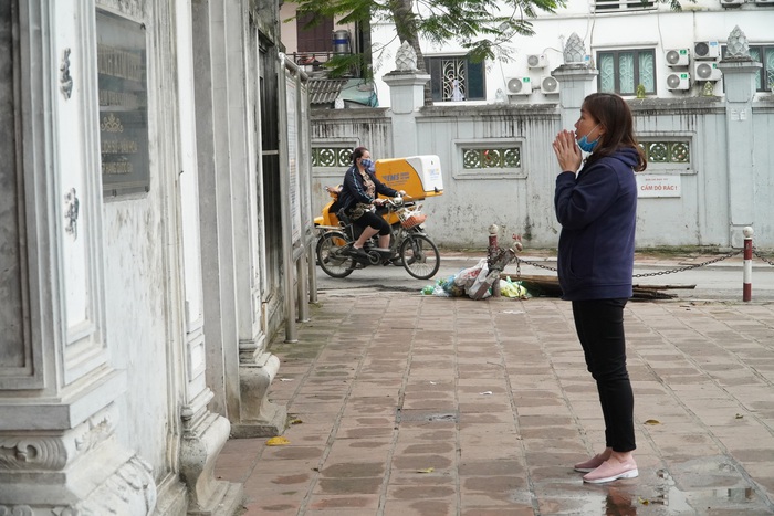 Đình chùa ở Hà Nội đóng cửa trong ngày đầu giãn cách xã hội, người dân đứng ở ngoài khấn vái  - Ảnh 6.