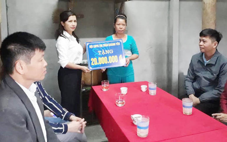 Bà Nguyễn Thị Én, Chủ tịch Hội LHPN thị trấn Khánh Yên trao tặng 20 triệu đồng hỗ trợ hội viên nghèo xóa nhà tạm