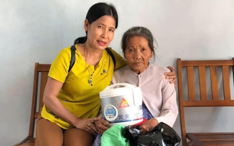 Chị Đinh Thị Thu (trái) trao quà cho phụ nữ nghèo