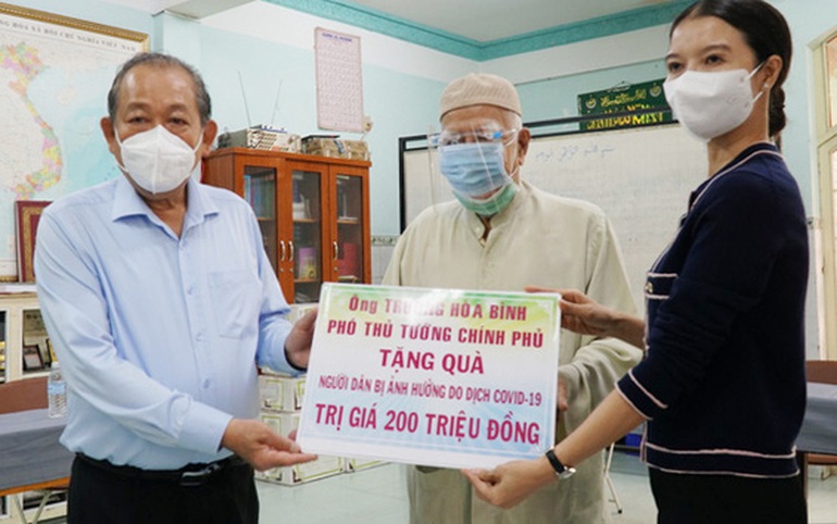 Phó Thủ tướng Thường trực Trương Hòa Bình (bìa trái) cùng nhà tài trợ trao bảng tượng trưng cho đại diện cộng đồng dân tộc Chăm. Ảnh: Đ.T