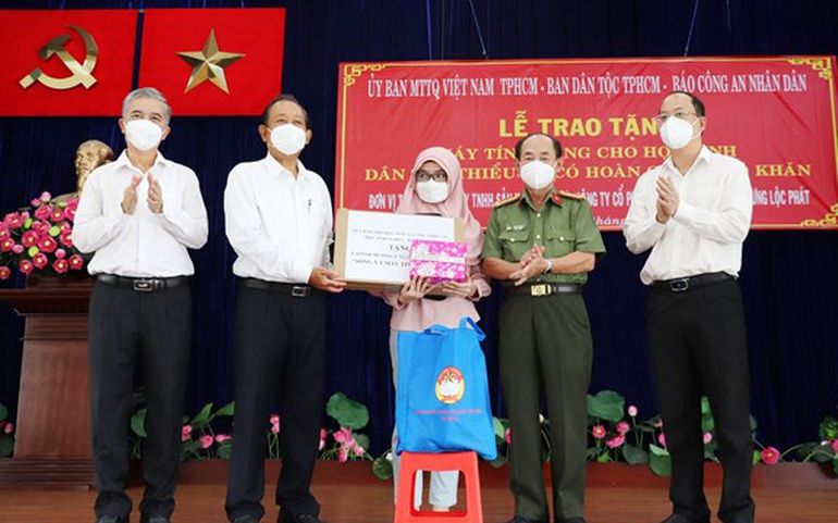 Nguyên Phó Thủ tướng Thường trực Trương Hòa Bình (thứ 2 từ trái qua) trao máy tính xách tay cho em Asikine Hồng, học sinh lớp 12 trường Tạ Quang Bửu, TPHCM