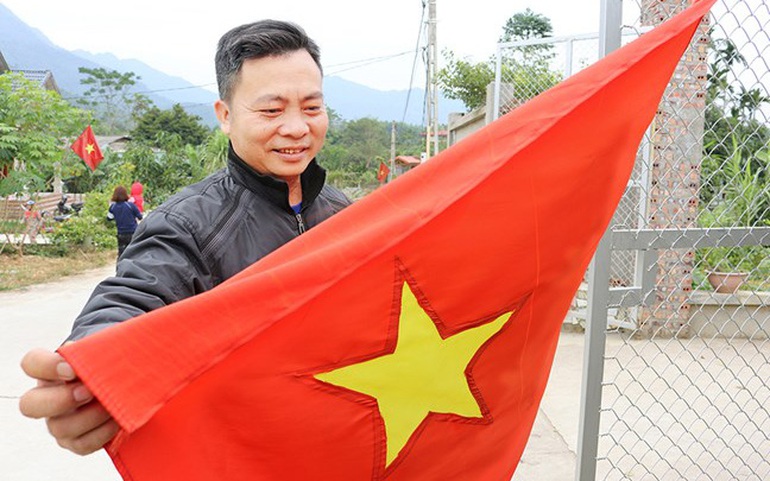 Ông Nguyễn Văn Tuấn - giáo dân họ giáo Hương Chan, xã Hương Lung, treo cờ Tổ quốc trước nhà