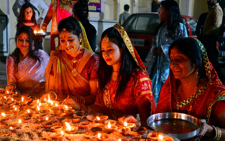 Phụ nữ thắp đèn để chào mừng lễ hội Diwali tại đền Shri Ram Chandra Ji ở Jaipur, Ấn Độ ngày 24/10. Ảnh: AP