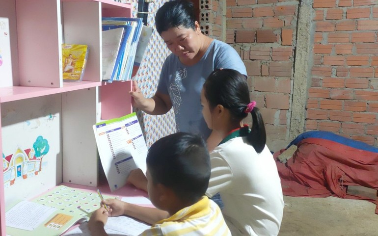 Chị Hồng Phúc kèm cặp các em học chữ ở Khe Su.
