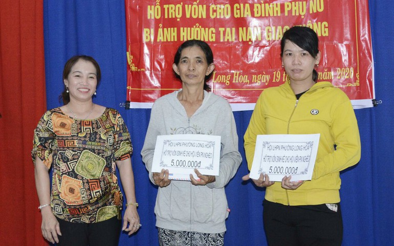 Chị Nguyễn Thị Bích Hoa (bìa trái) trao vốn không lãi suất cho gia đình phụ nữ bị ảnh hưởng tai nạn giao thông trên địa bàn.