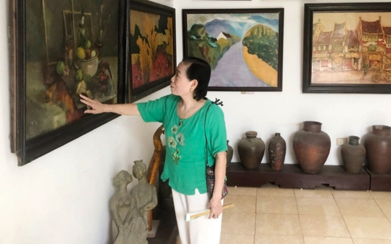 Họa sĩ Phan Thị Ngọc Mỹ giới thiệu với khách về một bức tranh mà bà tâm đắc