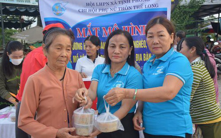 Bà Huỳnh Thị Mai (bìa phải) cùng cán bộ Hội xã Tịnh Phong (giữa) trao cháo cho bà con nghèo, khó khăn