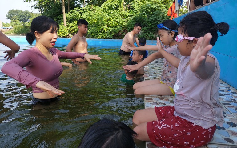 Thiếu tá Nguyễn Thị Ngọc Lan hướng dẫn kỹ năng bơi cho trẻ em tại xã Tam Hưng