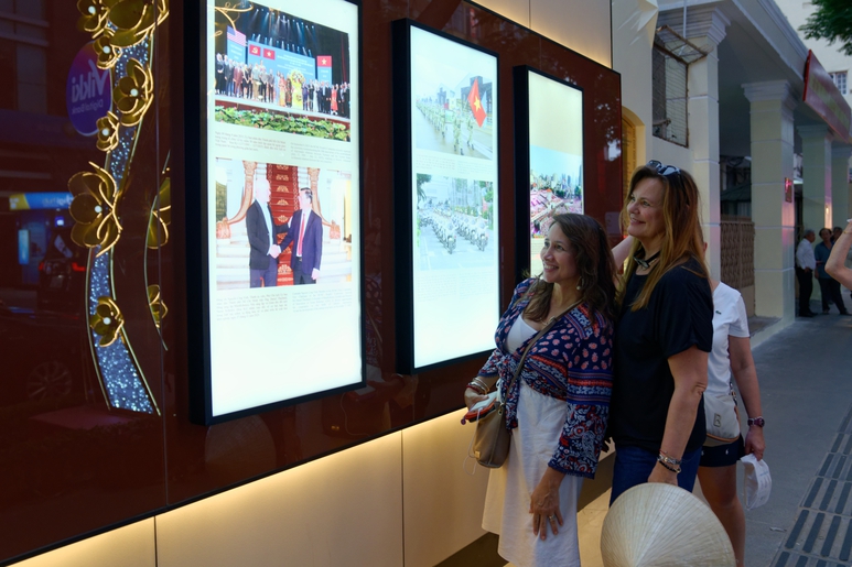 Nhiều du khách hào hứng thưởng lãm hình ảnh được trưng bày dọc trên đường Đồng Khởi trong ngày khai mạc Con đường nhiếp ảnh TPHCM