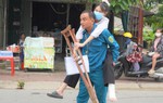 Bố cõng con đi thi, thí sinh được giáo viên viết bài thi hộ