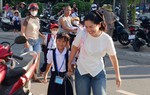 TPHCM: Học sinh lớp 1 tựu trường, phụ huynh đứng ngoài cổng dõi theo con