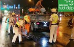 Cảnh sát giao thông hỗ trợ công nhân vệ sinh thu dọn vỏ chai đổ trên đường