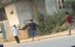 2 người đàn ông khiêng thi thể bó chiếu trên đường