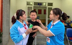 Cán bộ Hội phụ nữ tận tình chăm sóc bé trai bị lạc khi đi xem tổng hợp luyện diễu binh A80