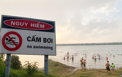Bất chấp biển cấm, nhiều người vẫn xuống sông Hồng tắm giải nhiệt