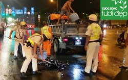 Cảnh sát giao thông hỗ trợ công nhân vệ sinh thu dọn vỏ chai đổ trên đường