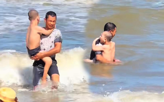 Ông bố ôm con trai ra biển Sầm Sơn tắm, câu chuyện đằng sau khiến người ta "cay mắt"