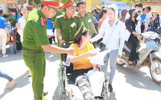 Công an trợ giúp nữ sinh ngồi xe lăn đi thi