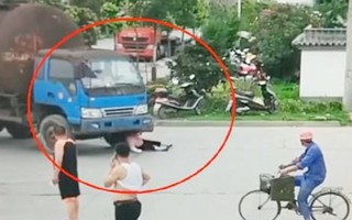 Người phụ nữ nằm lăn trước bánh xe tải để đòi bồi thường