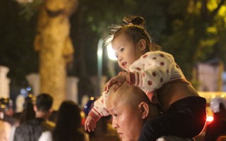 Những em bé theo chân bố mẹ chen giữa 'biển người' đêm Noel Hà Nội
